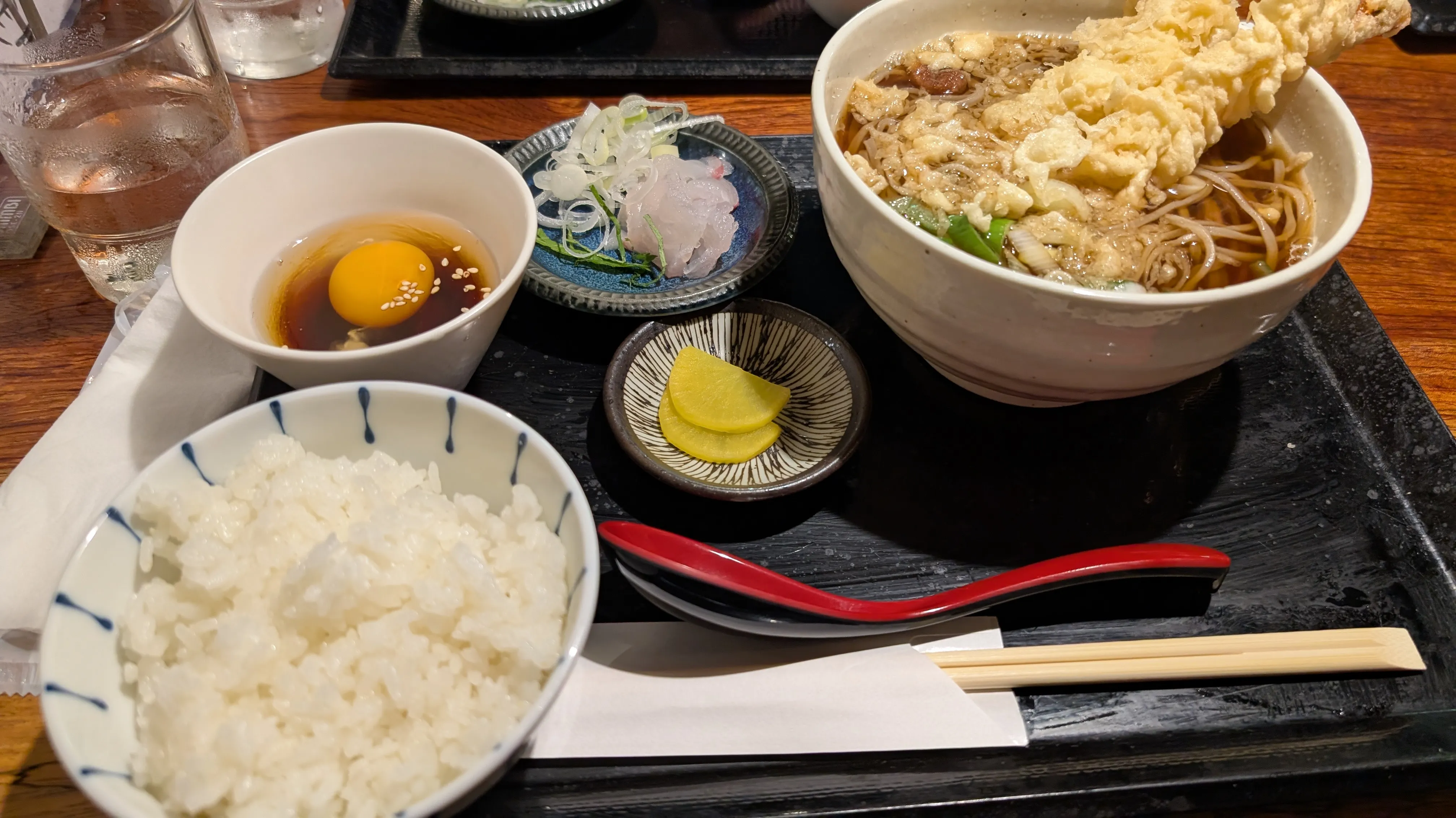 天ぷらうどん定食。生卵とご飯も添えられている。